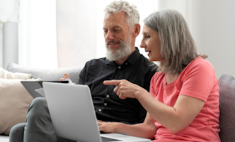 middelbaar-stel-achter-laptop-332x200