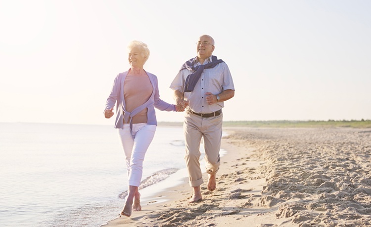 Een man en een vrouw die over het strand rennen.