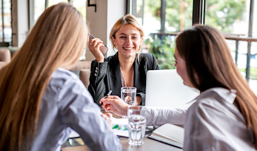 Drie dames vergaderen bij laptop